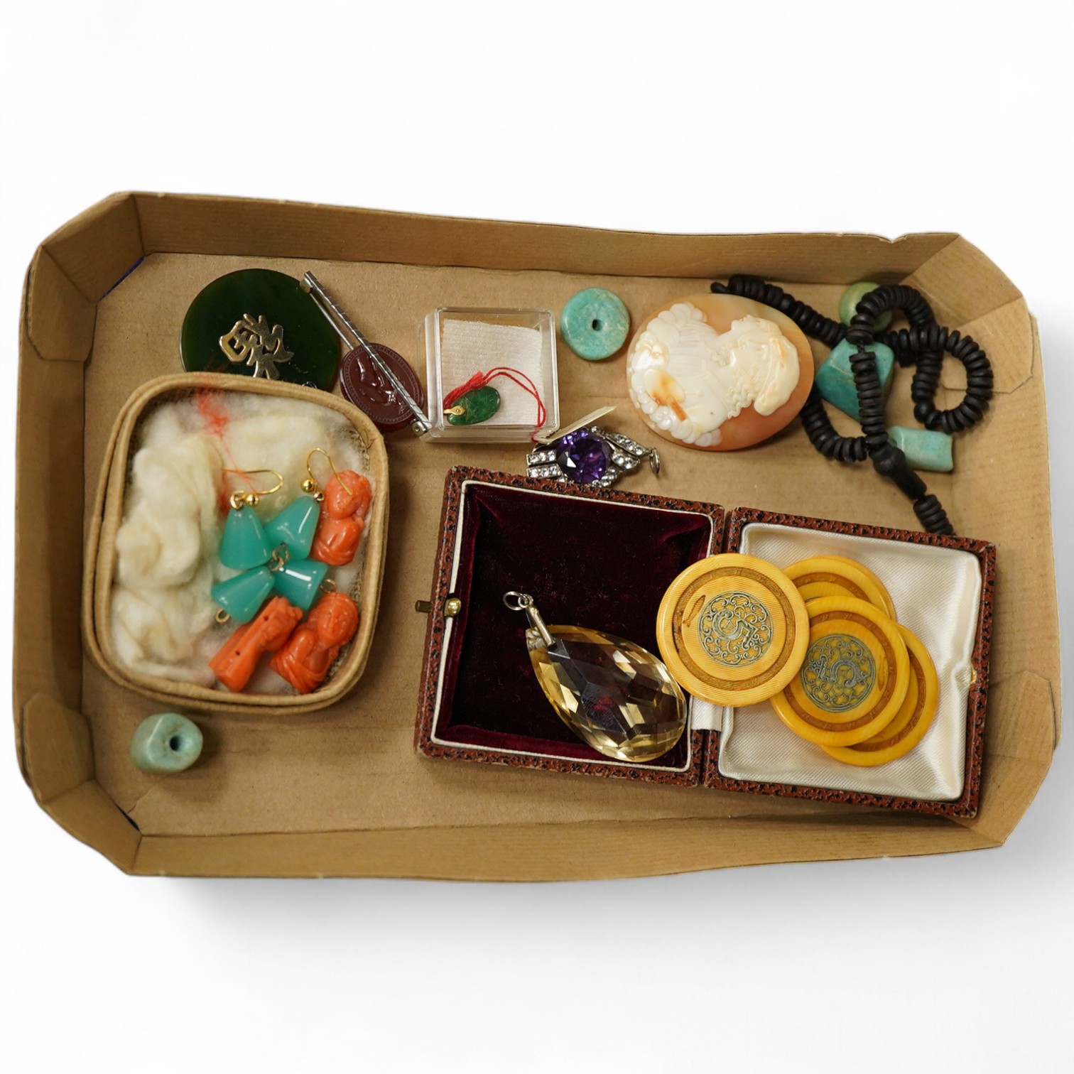 A group of jewels, comprising: three carved coral beads depicting classical women; a synthetic colour-change sapphire and paste pendant; a citrine drop pendant; a bar brooch with a scaraboid carnelian bead carved with an